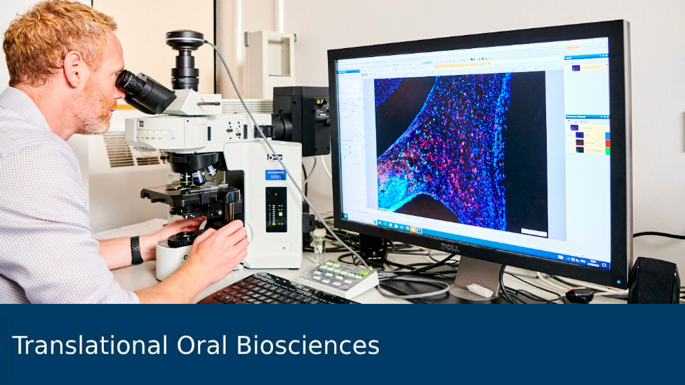 Researcher working with microscope in lab.